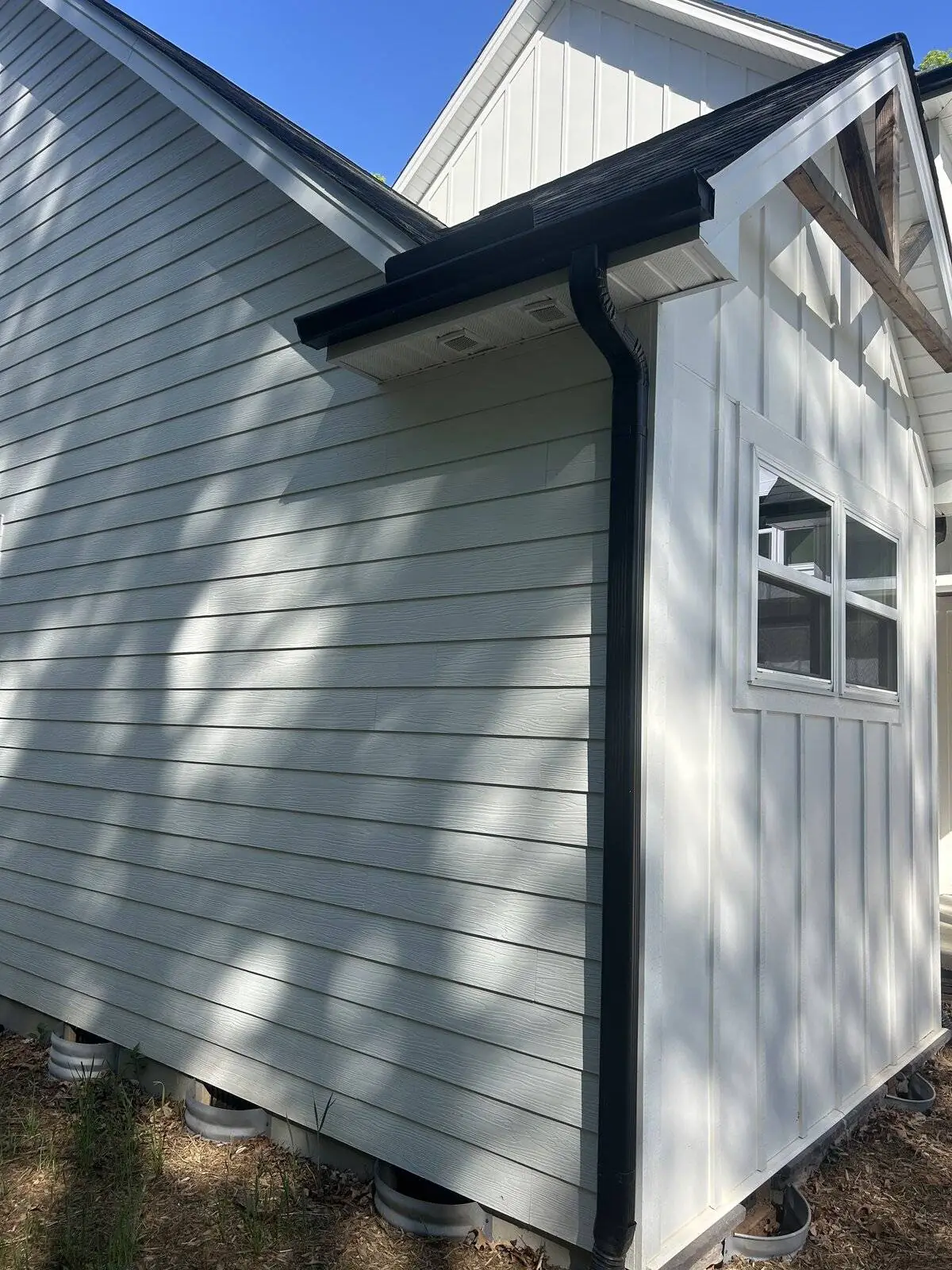Black gutter install on white board-and-batten home — Foothills Gutter Pro