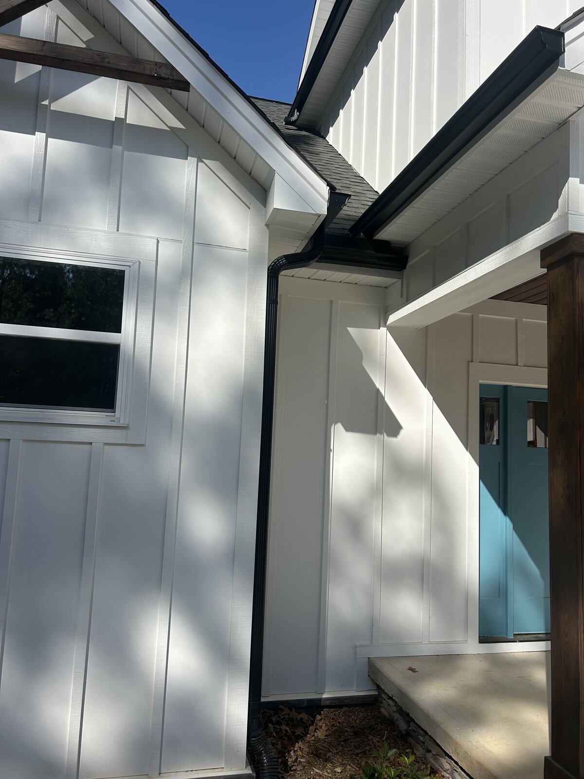 White board-and-batten home with seamless gutters — Foothills Gutter Pro